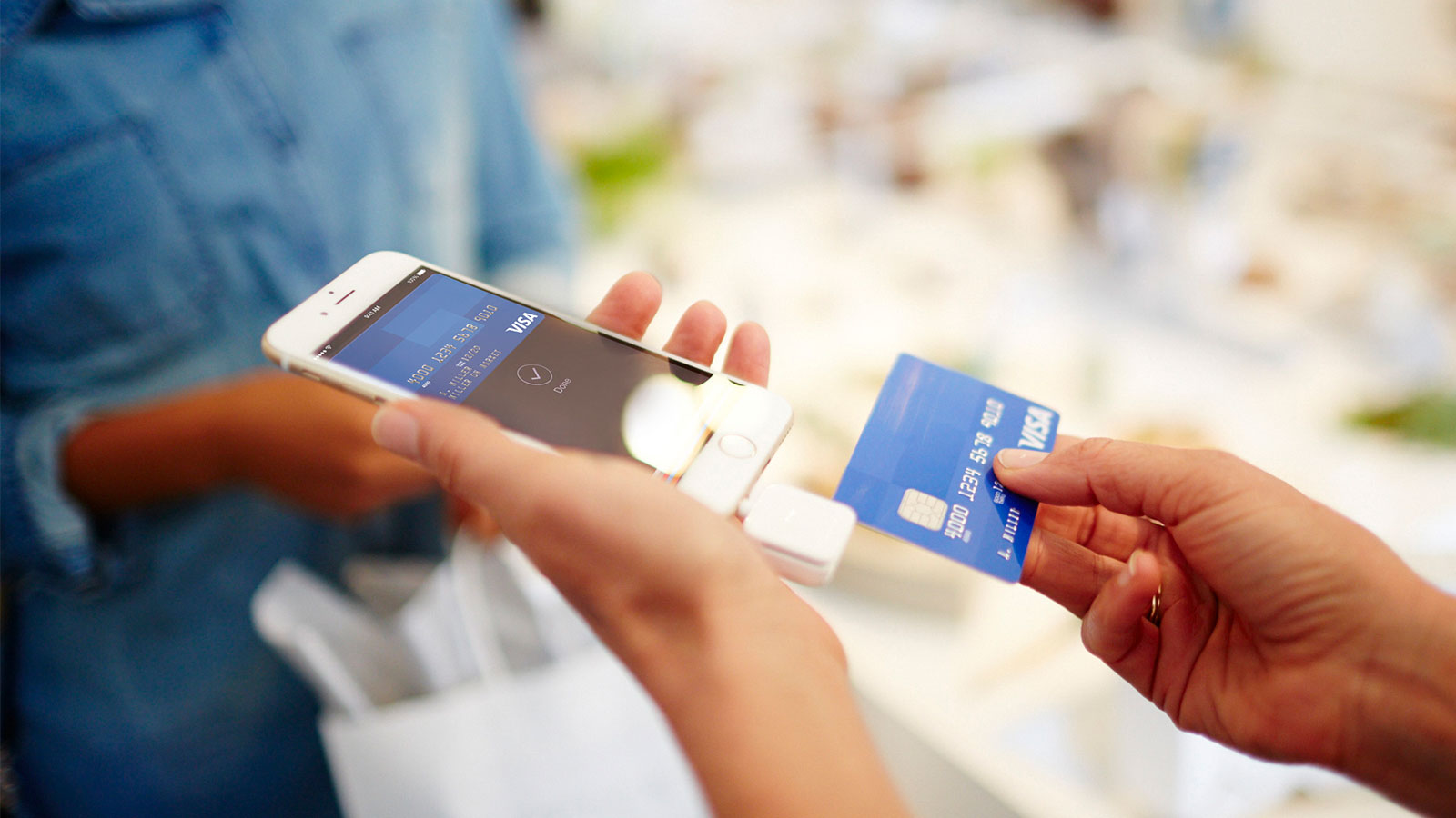 Woman handing off Visa Card to merchant